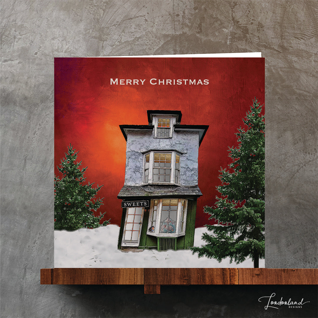 Orange Christmas card with a victorian wonky sweet shop with trees on an orange background