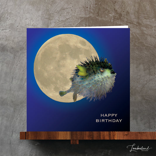 Birthday card with a puffer fish and moon design on a blue sky background