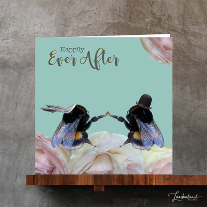 Card with two bees holding hands on flowers and 'Happily Ever After' text against a teal background.